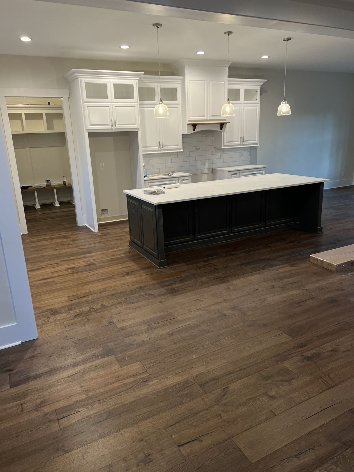 Dark wide-plank floor around a large kitchen island